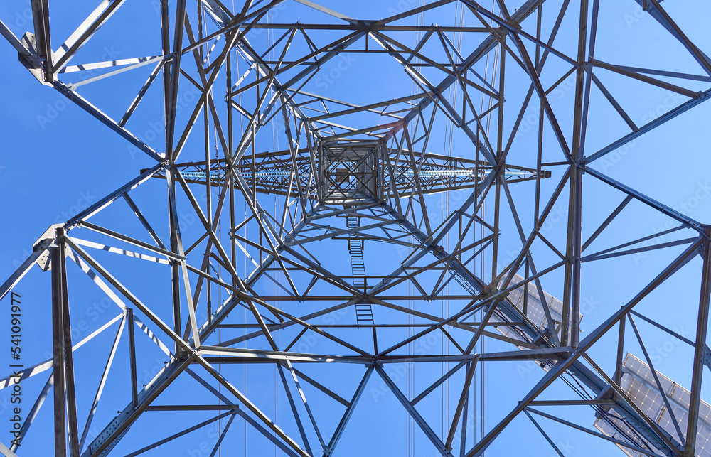Looking up into the structure of an electrical transmission tower