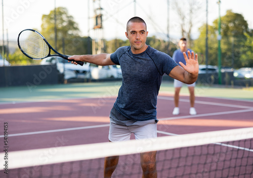 Caucasian man in sportswear playing tennis match during training on court. © JackF