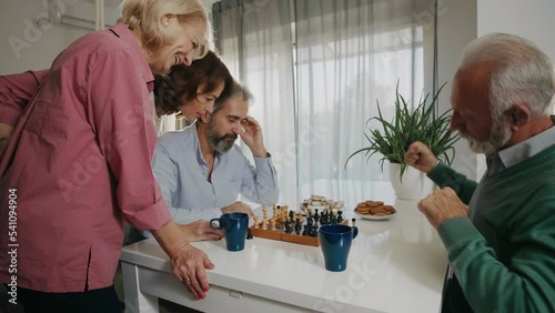 Two senior couples playing chess in pairs