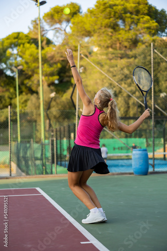 Woman tennis player training on court. Woman using racket to hit ball.