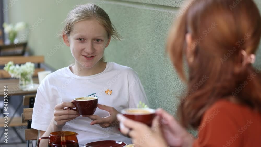 mother and daughter sitting in the street caffee