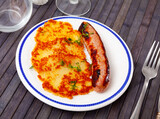 Traditional Belarusian dish is draniki, made from raw grated potatoes, served with an appetizing fried sausage on a plate