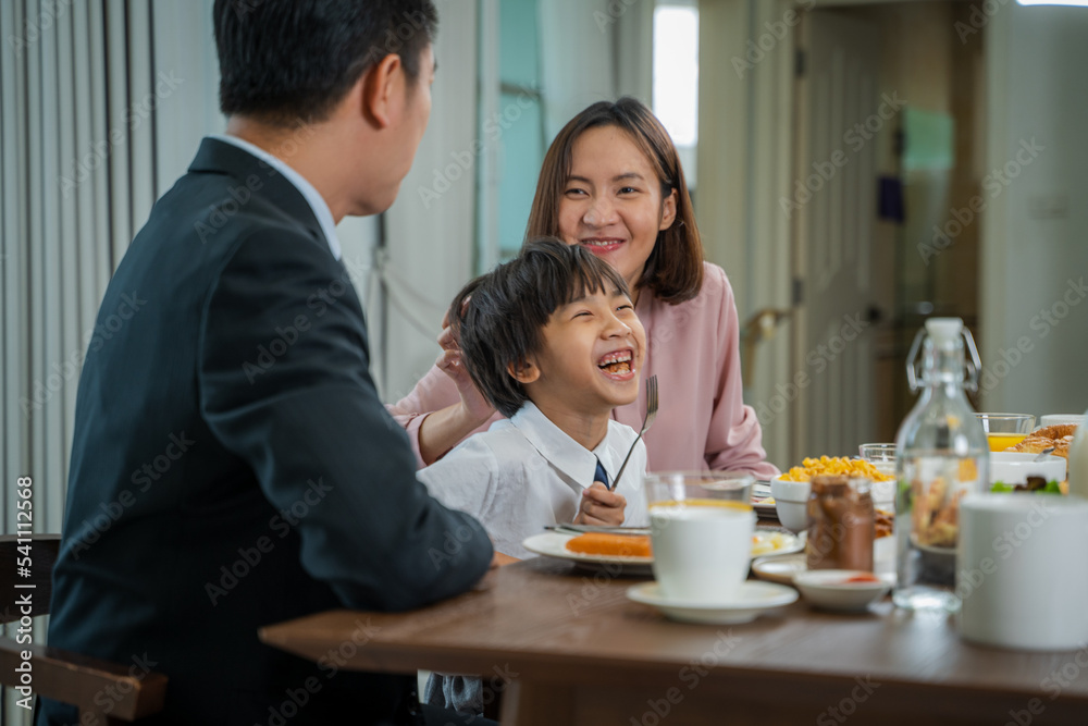 Happy parents feeding their son during breakfast time in the kitchen,Before going to school. Happy parents feeding their son during breakfast time in the kitchen,Before going to school.