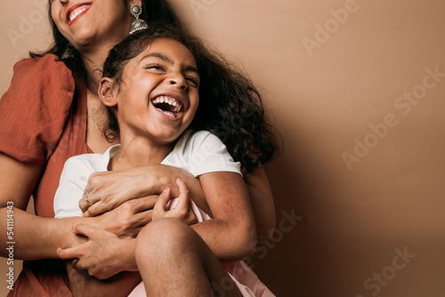 Mom and daughter laughing in a studio 