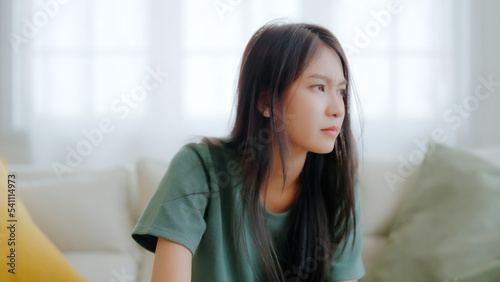 Upset asian woman frustrated by problem with work or relationships, sitting on couch, feeling despair and anxiety, loneliness, having psychological trouble