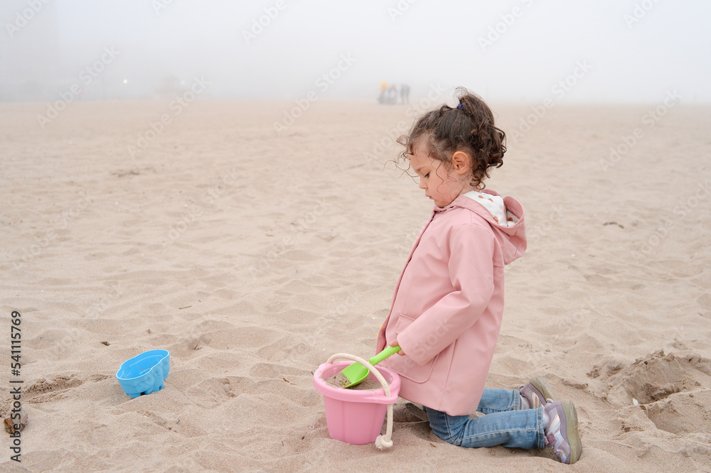 Expressive young girl is playing on the beach on a very foggy day Expressive young girl is playing on the beach on a very foggy day