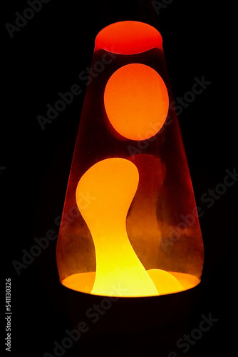 A retro style lava lamp glows in a dark room photo