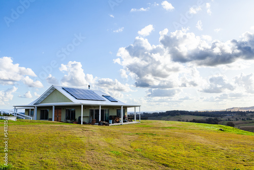 House in the country on a hilltop with solar panels for off grid sustainable living