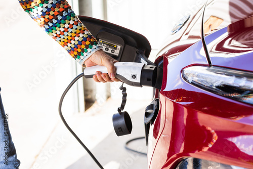 Close up of electric vehicle charging plug being plugged into ev car