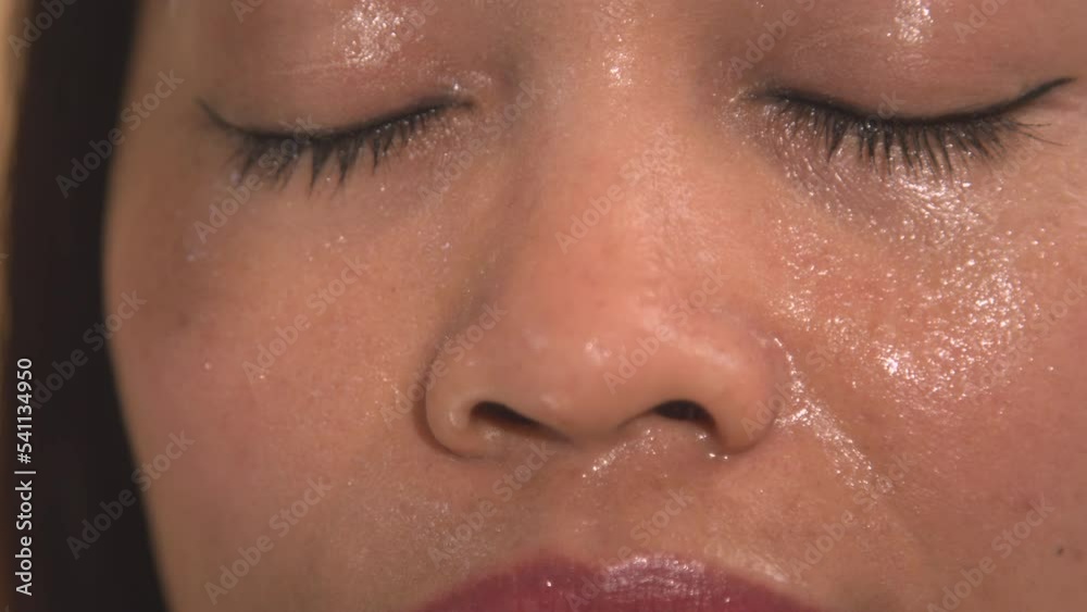 PORTRAIT, CLOSE UP: Young lady opening her eyes while sweating in Finnish sauna. Sweaty woman relaxing in wooden sauna for detoxification and strengthening of the immune system in cold winter months.