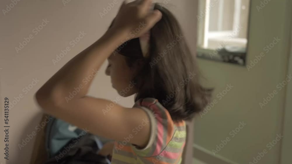 Blurry short haired girl in her crop top combs hair in front of the mirror and adjusting hairband, side view Blurry short haired girl in her crop top combs hair in front of the mirror and adjusting hairband, side view