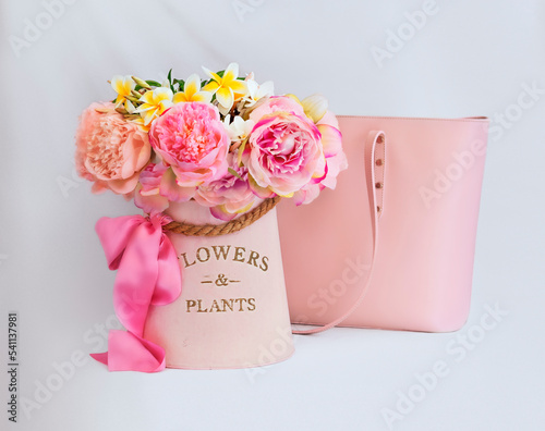 Still life with flowers and a bag in pink tones