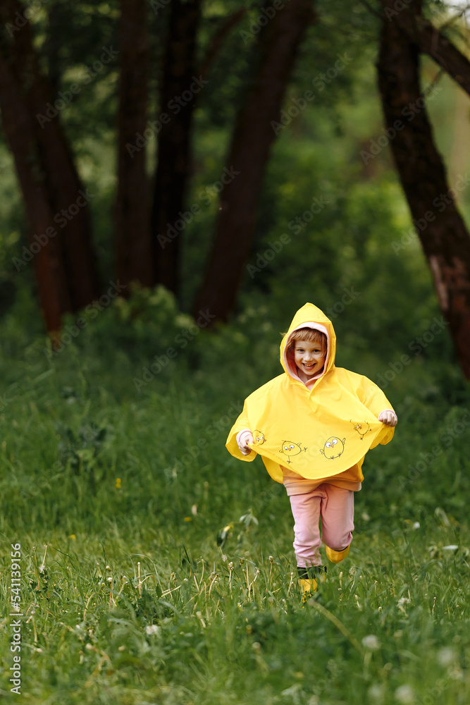 Happy funny baby under autumn shower. Girl running merrily laughing in the rain Happy funny baby under autumn shower. Girl running merrily laughing in the rain