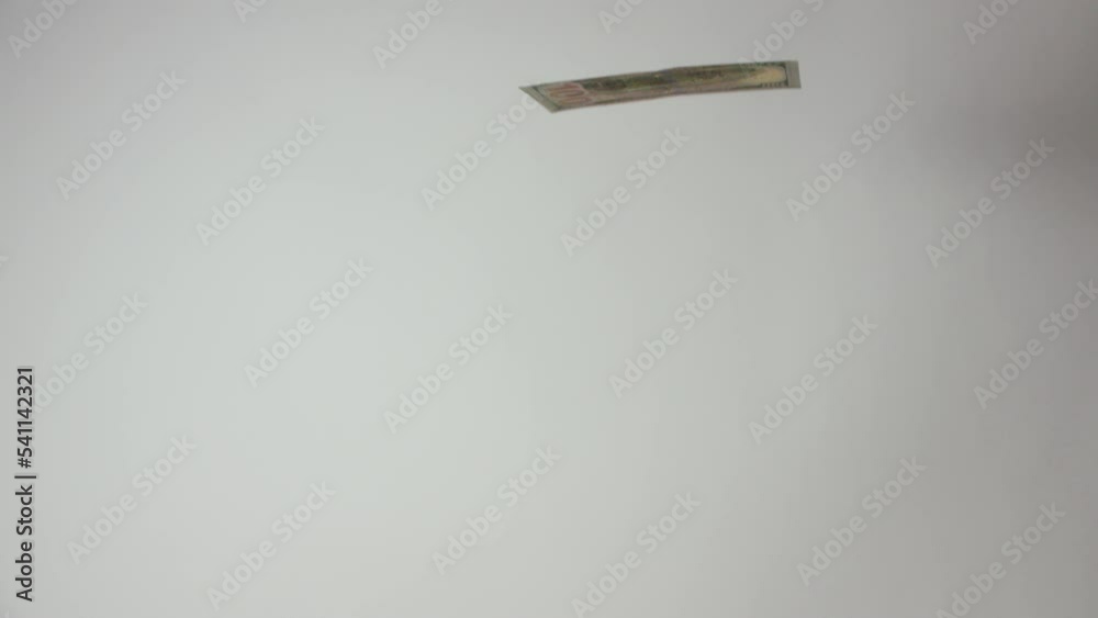 U.S.A. One Hundred Dollar Bill Flipping Downward Toward Camera, Crashing Directly Into Camera, On White Background U.S.A. One Hundred Dollar Bill Flipping Downward Toward Camera, Crashing Directly Into Camera, On White Background