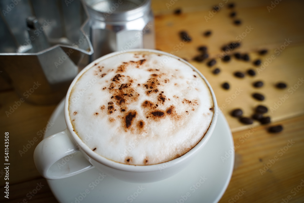 Hot cappuccino in white cup with wooden background,coffee is a popular drink all over the world. Hot cappuccino in white cup with wooden background,coffee is a popular drink all over the world.