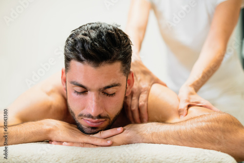 Relaxing young man on massage table in spa