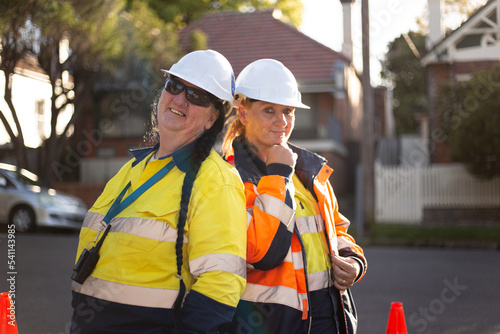 Two women road workers wearing white helmet with high vis workwear photo