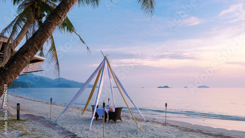 Romantic dinner on a beach in Koh Chang Thailand during sunset. Table with dinner on a beach  photo