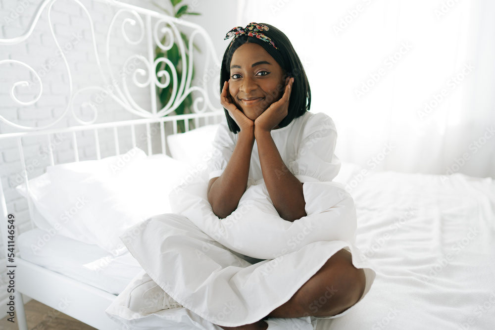 Beautiful young thoughtful african woman sitting in morning bed Beautiful young thoughtful african woman sitting in morning bed