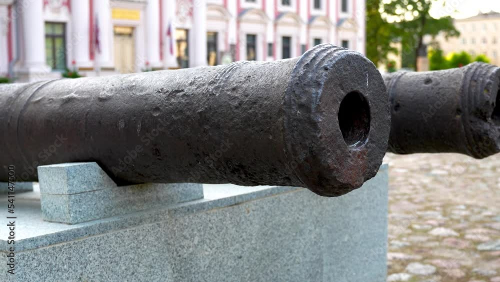 Close-up of two antique iron cannons with exposed bullet holes in a square Close-up of two antique iron cannons with exposed bullet holes in a square