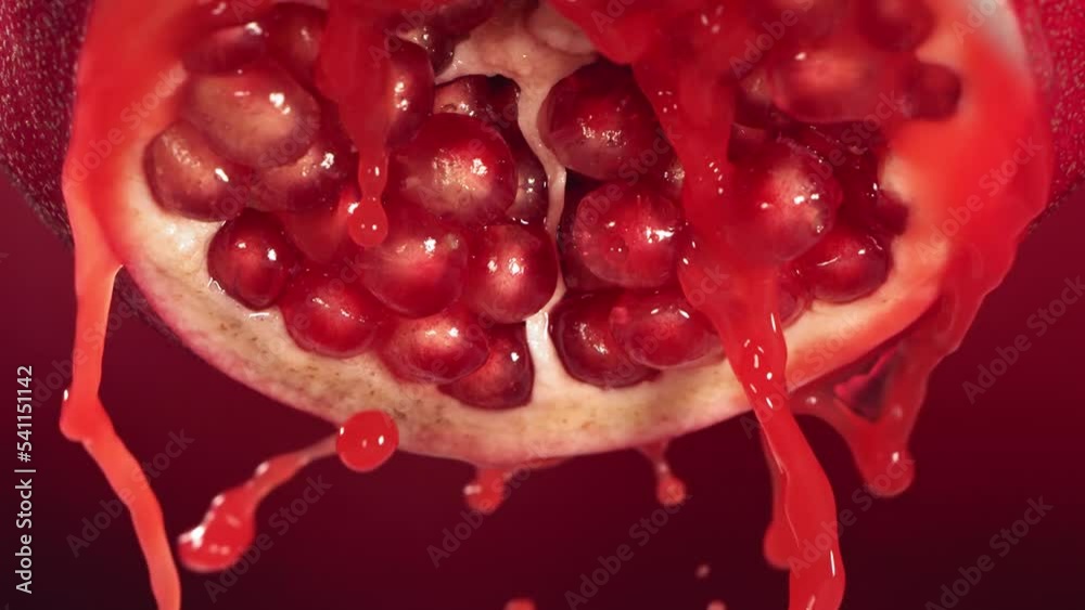 Slow Motion of Flowing Pomegranate Juice from Half Pomegranate Slow Motion of Flowing Pomegranate Juice from Half Pomegranate