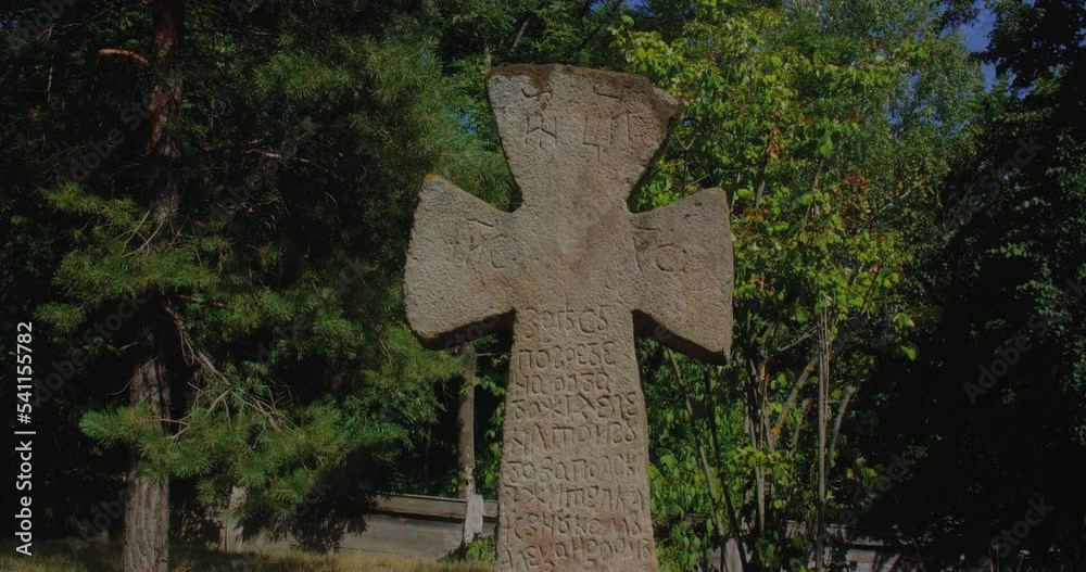 Ancient stone Slavic cross with inscriptions. Ukrainian culture and history, Holy places, old tombstone. Ancient stone Slavic cross with inscriptions. Ukrainian culture and history, Holy places, old tombstone.