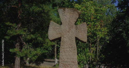 Ancient stone Slavic cross with inscriptions. Ukrainian culture and history, Holy places, old tombstone.