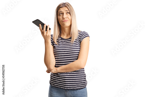 Photography Bored young woman listening to phone conversation on speakerphone