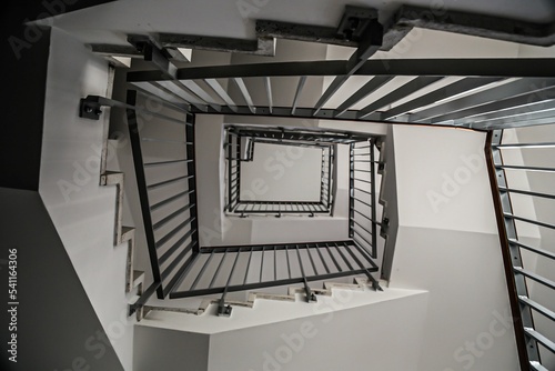 Low-angle shot of a minimalistic staircase with black railings photo