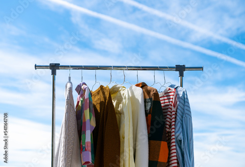  Low angle view at colourful clothes hanging on rail against blue sky.