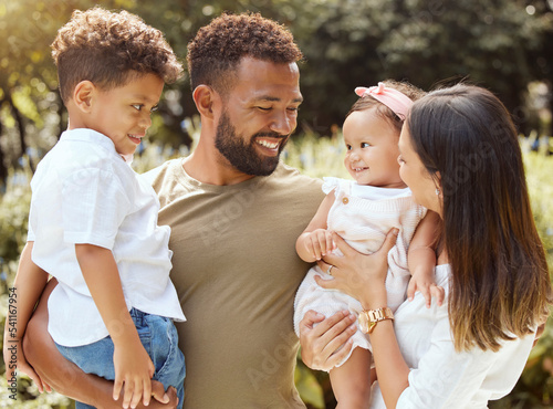 Black family, happy and nature park with people holding a child and baby outdoor. Mother, father and children together in the summer sun with happiness smile and kids spending quality time outdoors