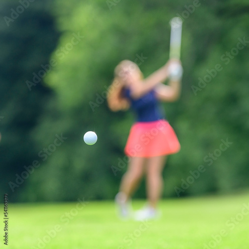 Golfspielerin in Unschärfe beim Schwung
