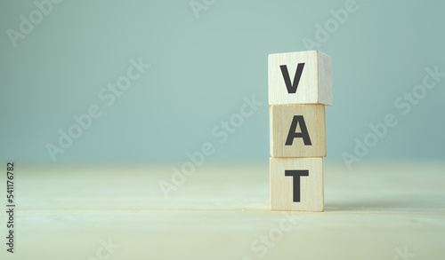 VAT concept. Value Added Tax. VAT text on wooden cubes with grey background.