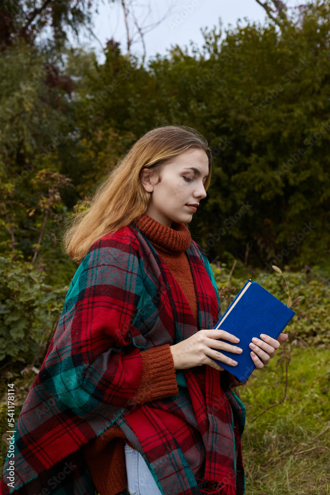 portrait of a beautiful, charming woman in an autumn forest with a book in her hands portrait of a beautiful, charming woman in an autumn forest with a book in her hands