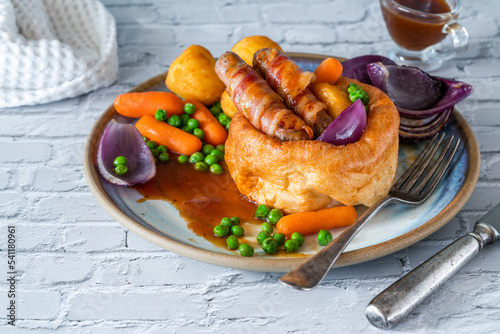 Toad in the hole with Yorkshire pudding, sausages and vegetables photo