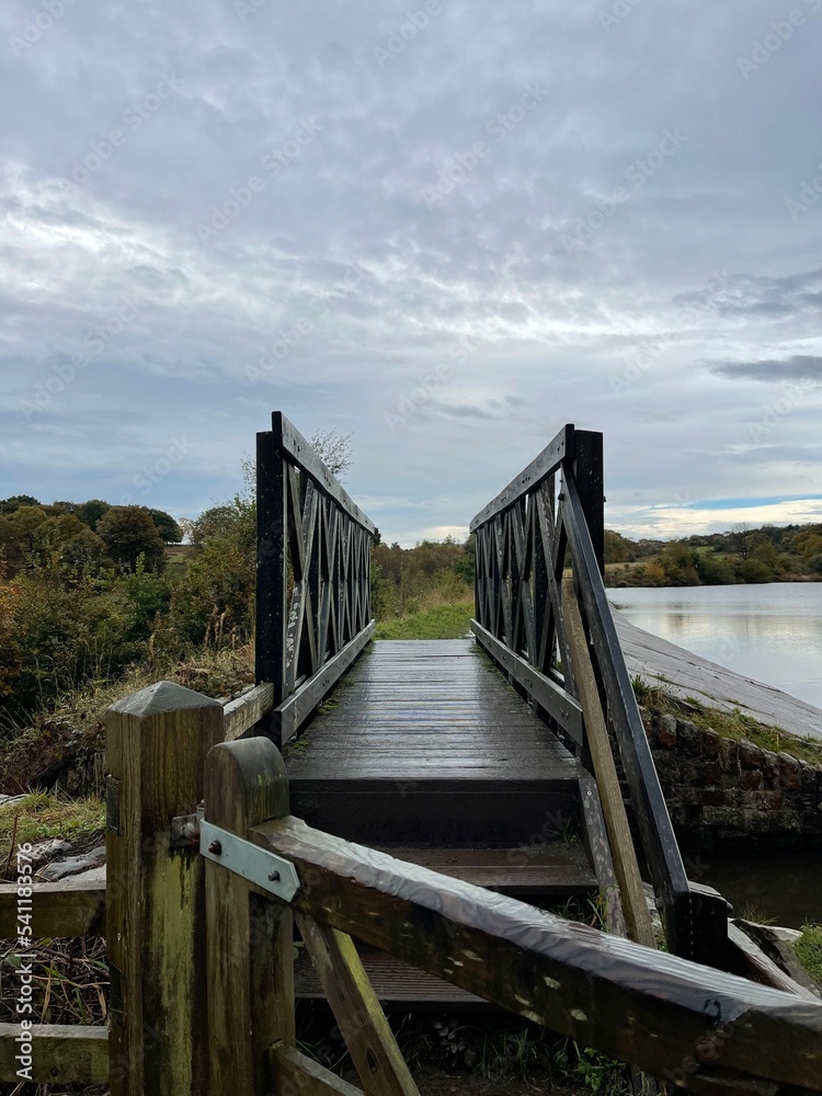 Wooden bridge crossing over a lake in the countryside. Taken in Bury Lancashire England. 