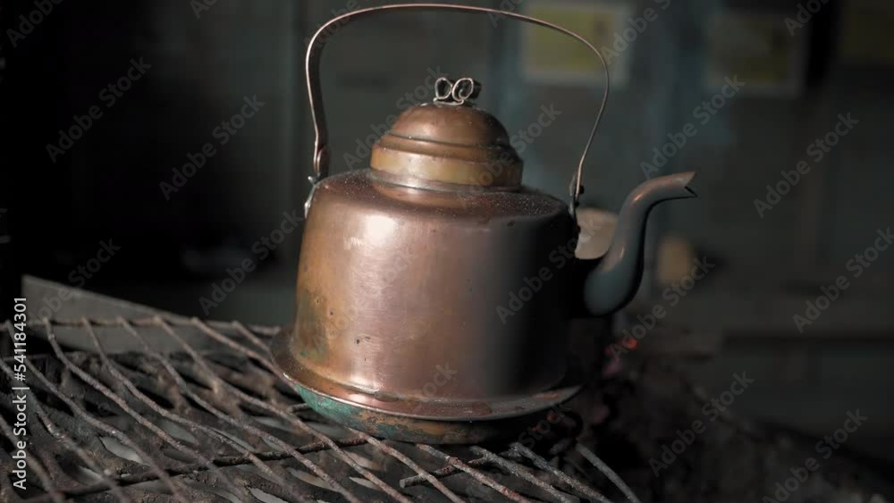 A Man Puts A Copper Kettle on The Fire. Evening in the forest. A place for grilling. Outdoor recreation. A Man Puts A Copper Kettle on The Fire. Evening in the forest. A place for grilling. Outdoor recreation.