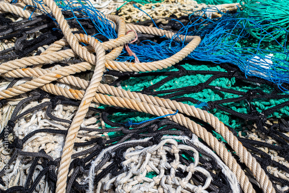 Cuerdas y redes de pesca de varios colores en el suelo del pequeño puerto pesquero del pueblo Blanes en Cataluña.