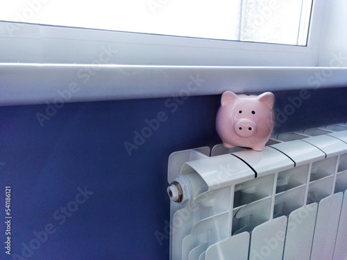 Piggy bank money saving box with a radiator. Household heating cost concept.