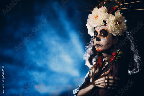 Fototapeta Naklejka Na Ścianę i Meble -  Woman with mexican skull halloween makeup on face. Day of the dead aka Dia de los Muertos and halloween concept.