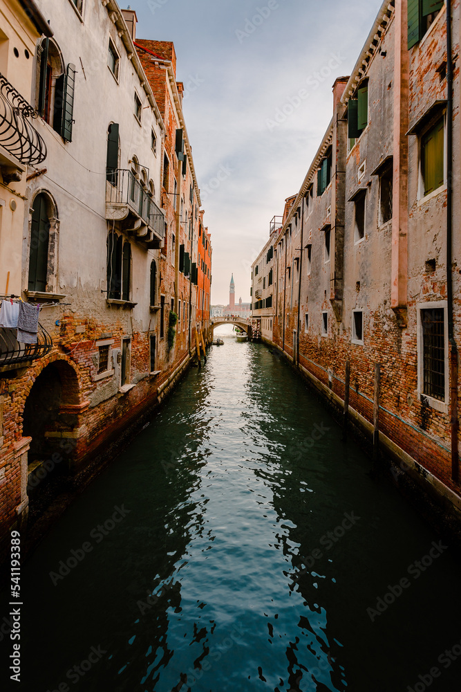 Venice canal with bridge and bell tower in the background