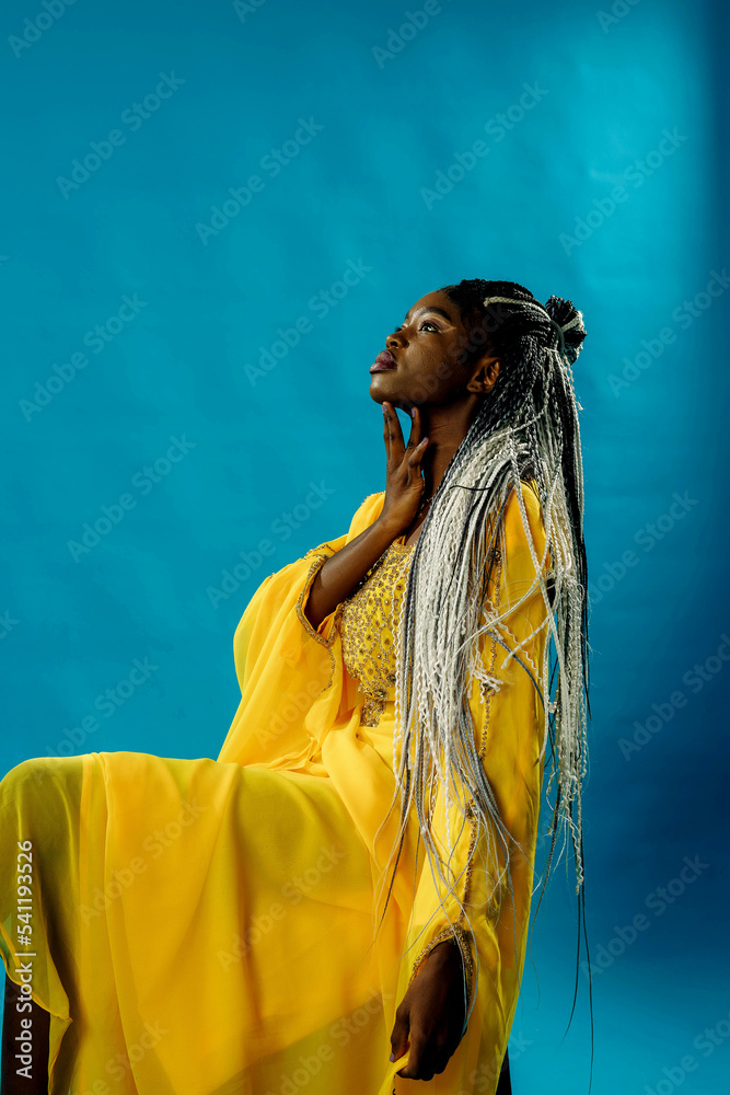 a girl in a yellow dress on a blue background