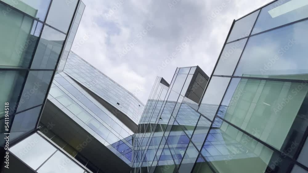 Contemporary glass skyscraper under cloudy sky Contemporary glass skyscraper under cloudy sky