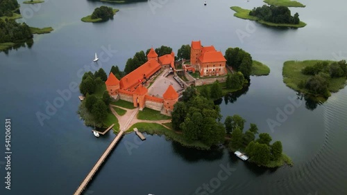 An aerial shot of the Trakai castle, medieval gothic Island castle,  surrounded by green trees over the Galves lake in Trakai, Lithuania photo