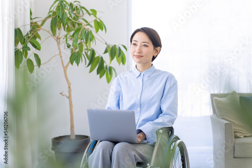 パソコンを使う女性・身体障がい者・車椅子