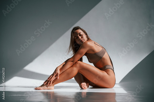Young woman in underwear is in the studio. On the floor