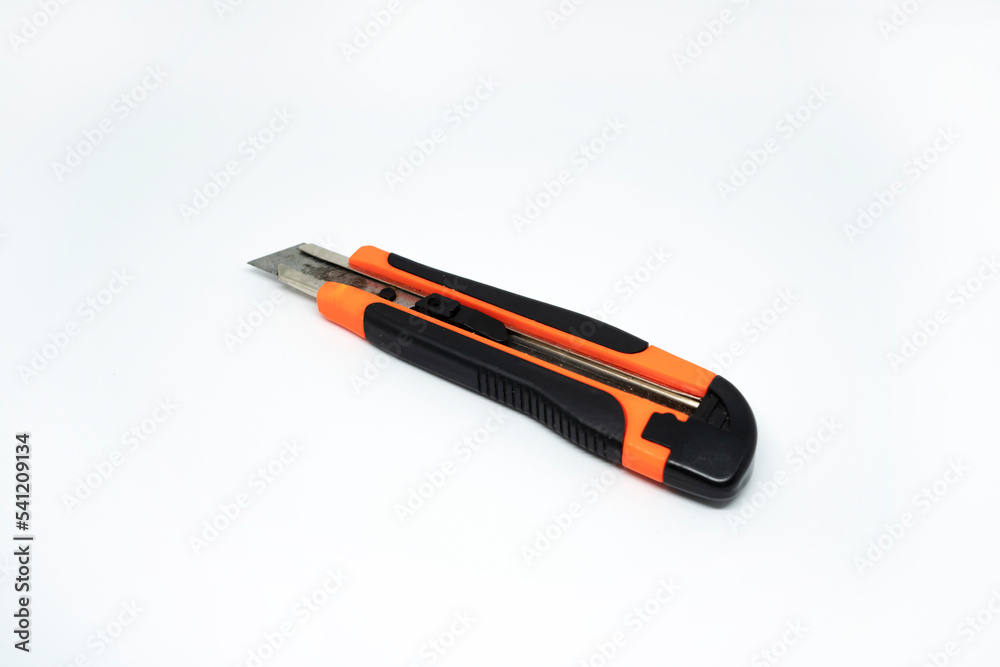 Closeup view of orange cardboard cutter isolated on white background. Box cutter isolated Closeup view of orange cardboard cutter isolated on white background. Box cutter isolated