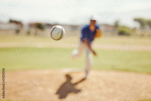 Sports, pitch and baseball ball in air, pitcher throwing it in match, game or practice in outdoor field. Fitness, exercise and training on baseball field with player in action, movement and motion photo