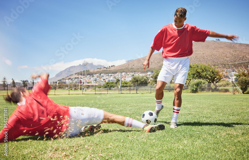 Men, soccer and slide tackle in sports fitness, training and exercise on the field outdoors. Athletic man tackling football player in sport for control, possession or defense in game or match outside