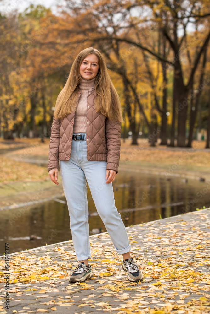 Happy beautiful red-haired woman posing in autumn park Happy beautiful red-haired woman posing in autumn park